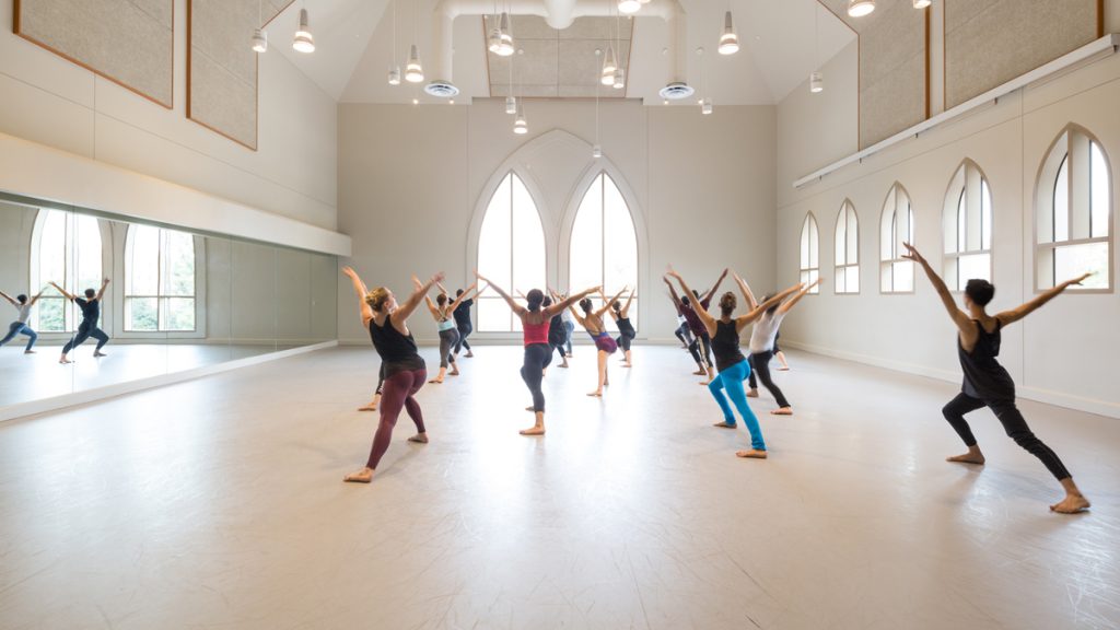 dance students with their backs facing the camera and arms up in a V