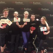 five students smile holding signs