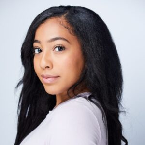 close up of a girl with long black hair wearing a white shirt