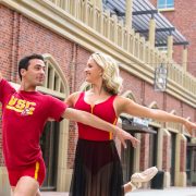 Man and woman in red and yellow dance attire outside at USC Village.