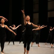 ballet students on stage wearing black tanks and tights