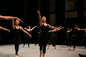 ballet students on stage wearing black tanks and tights