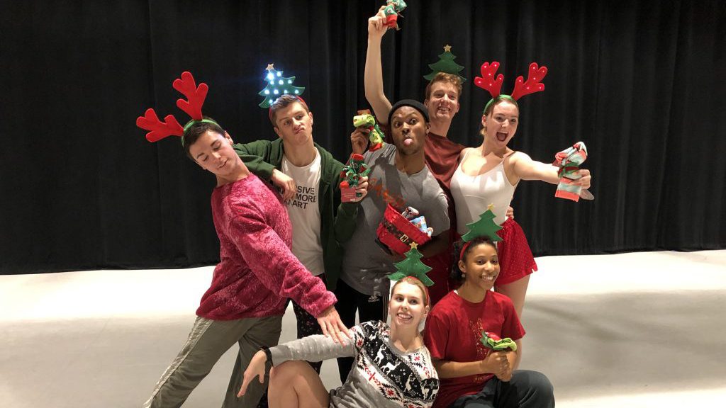 seven dancers pose wearing holiday-themed head bands