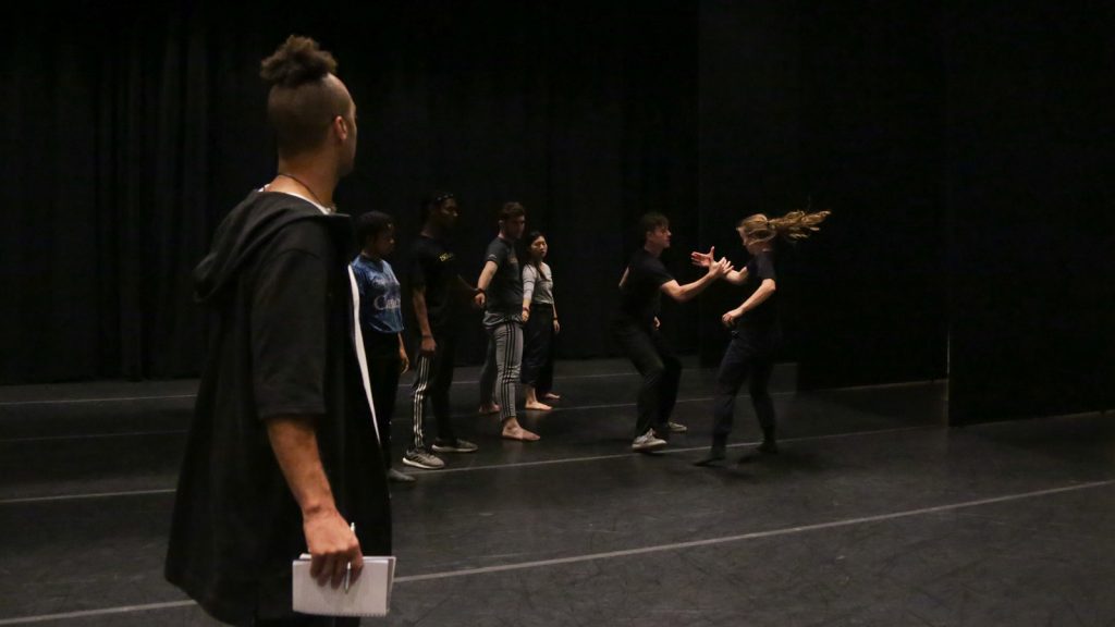 Director watching dancers execute handshake movement