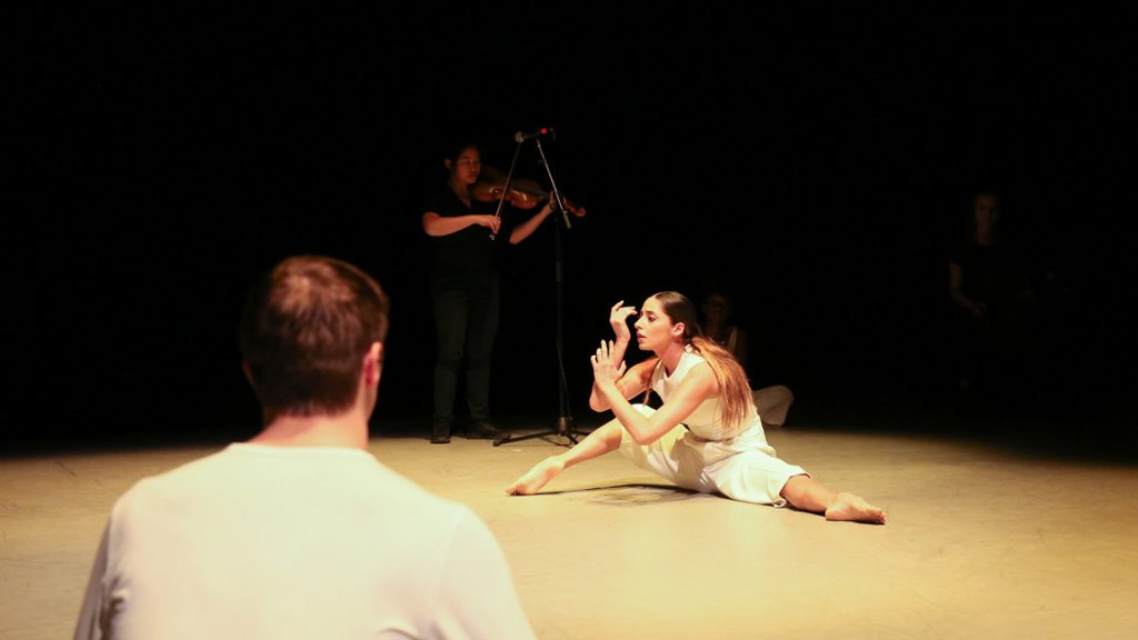 Dancers onstage with string musicians