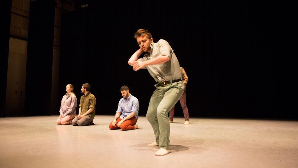 Dancers kneeling behind soloist