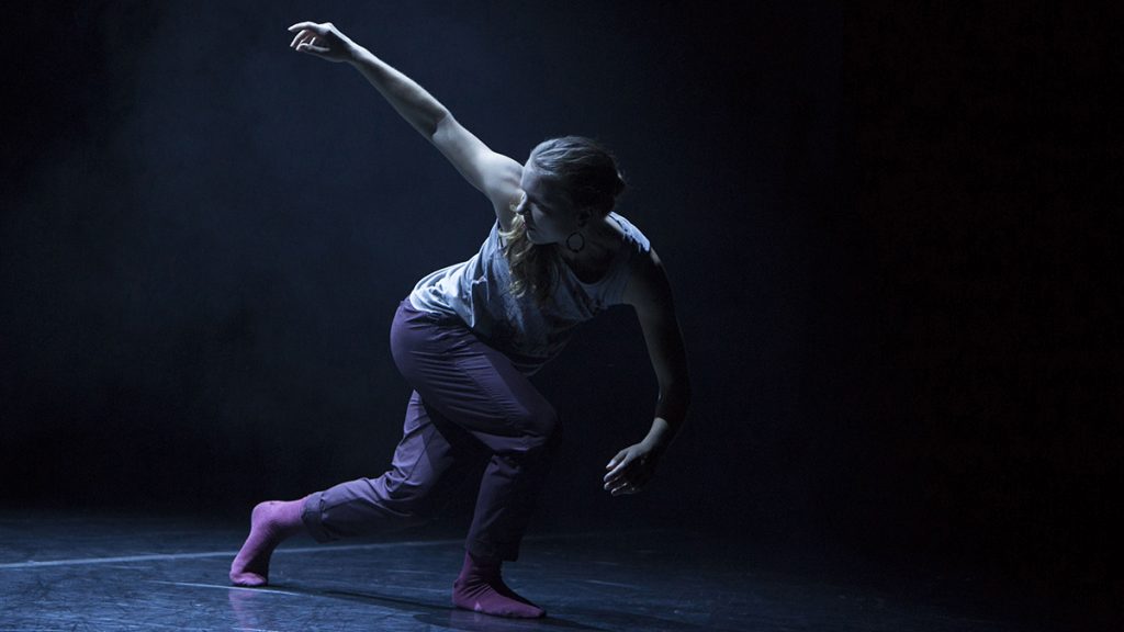 female dancer looking to her right with her right arm up