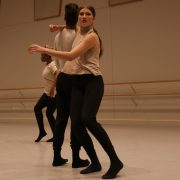 dancers wearing black pants and light tops in studio