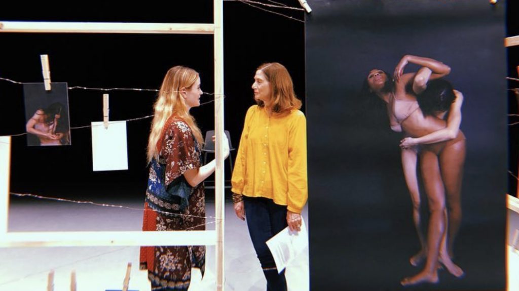 two women speaking surrounded by dance photographs