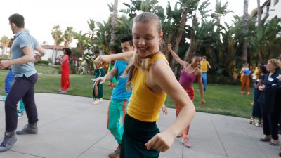 Girl in yellow top dancing and smiling