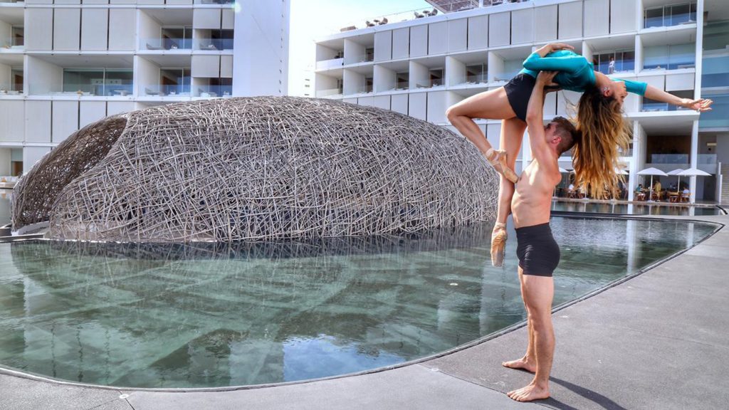 Man holding woman in lift near water feature