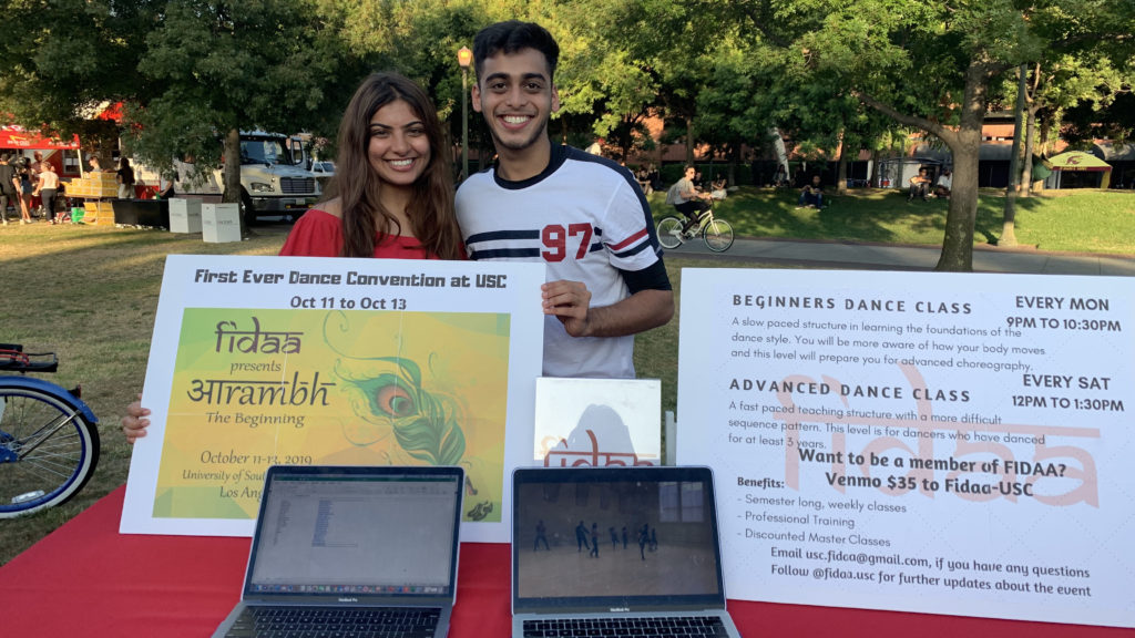 Jainil and another member of FIDAA pose in McCarthy Quad with a poster advertising their club.