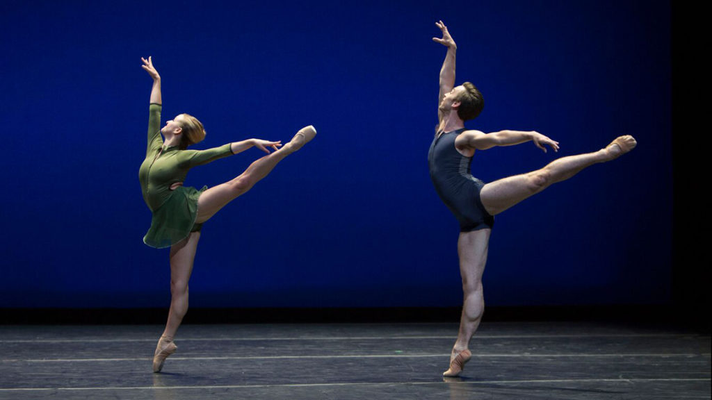 Woman in green and man in blue in arabesque