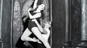 black and white photo of one dancer lifting another wearing pointe shoes