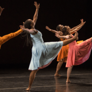 dancers with right legs and both arms in air