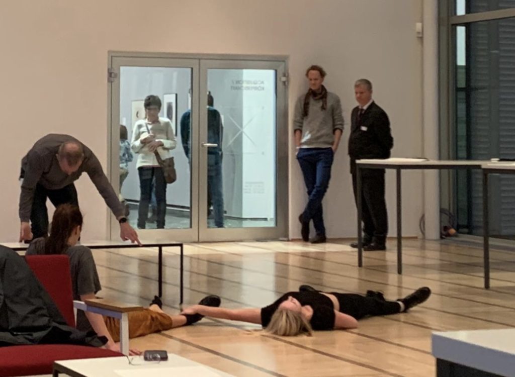 Dancers lie on the floor in the museum