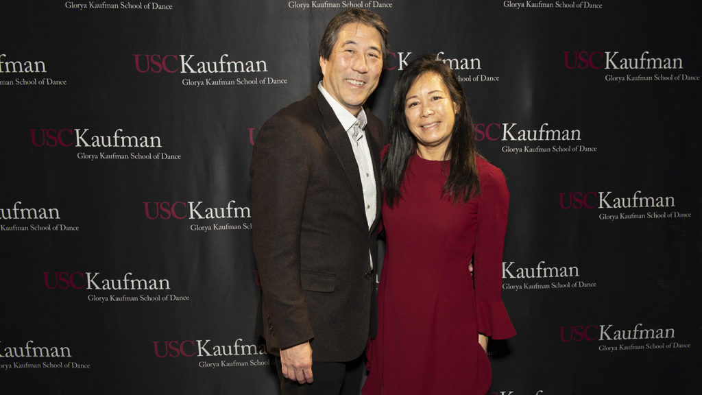 Rod and Elsie Nakamoto smile in front of a USC Kaufman step and repeat