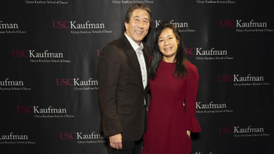 Rod and Elsie Nakamoto smile in front of a USC Kaufman step and repeat