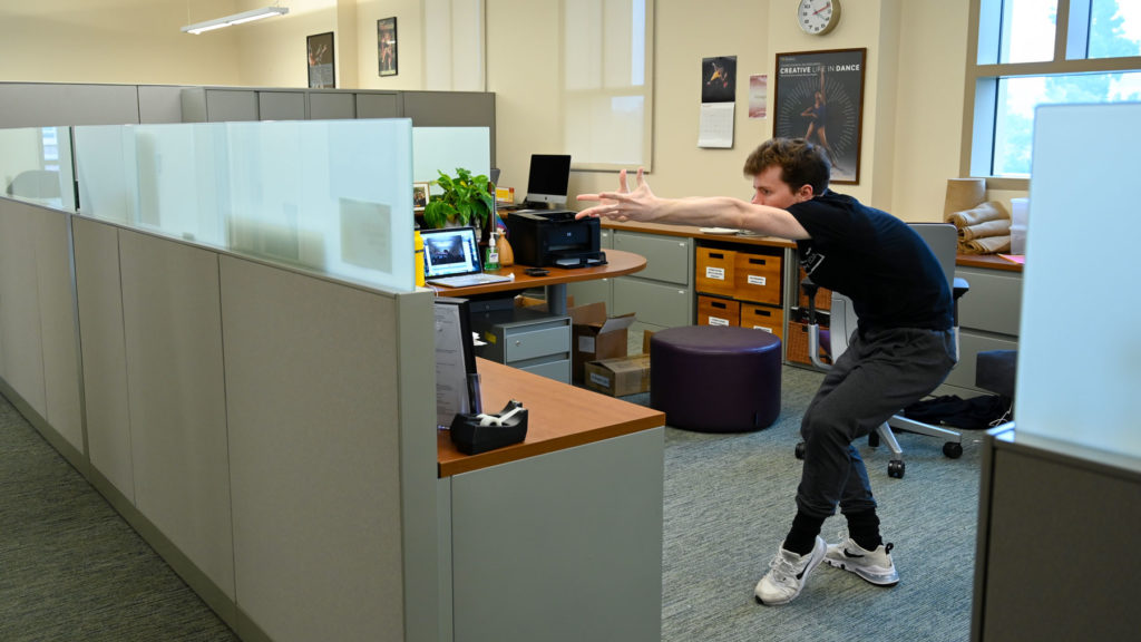 A student dances in a cubicle