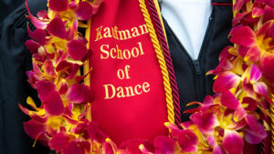 Cardinal sash with gold lettering and colorful lei