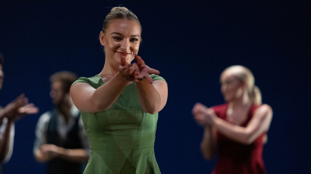 Whitney Hester dancing in a green dress.