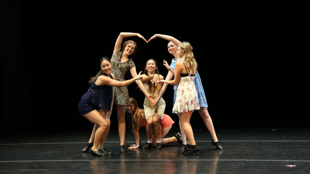 Dancers make a heart with their bodies on stage