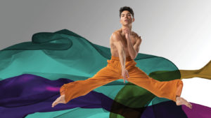 Benjamin Peralta jumping in front of multi colored fabric