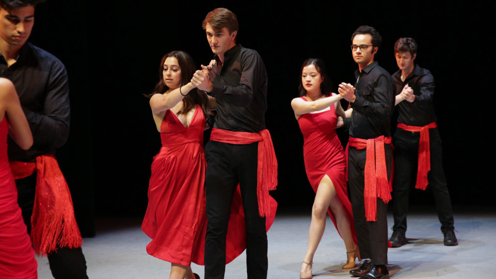 Students dresses in black and red perform on the USC Kaufman stage