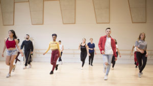 Dancers walking forward in a studio during a commercial dance class