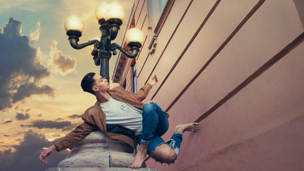 Diego Lopez in a white shirt and jeans posing against a wall