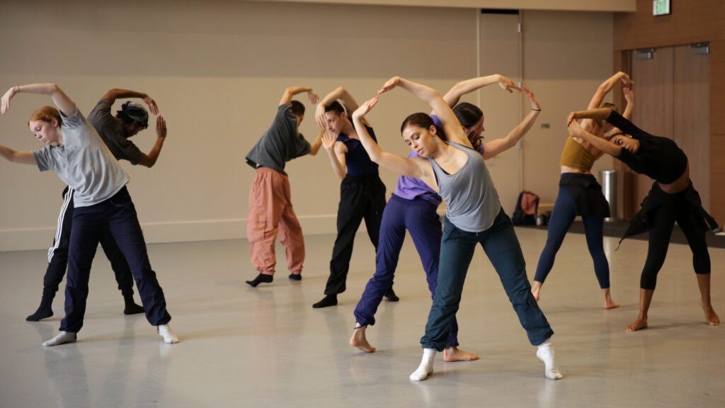 dancers in a studio on tiptoes with rounded arms