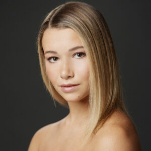 Ava Noble looking into camera in front of black background