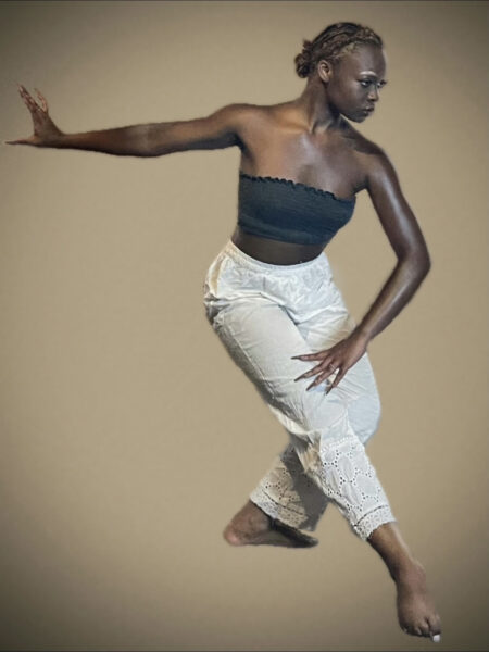 dancer posing in a strong position with one leg out in front in white pants and a black tube top.