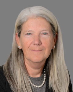 woman with gray hair wearing a pearl necklace