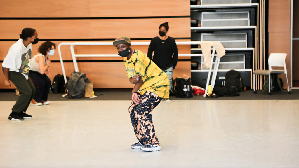 Dancer wearing yellow shirt in front of studio