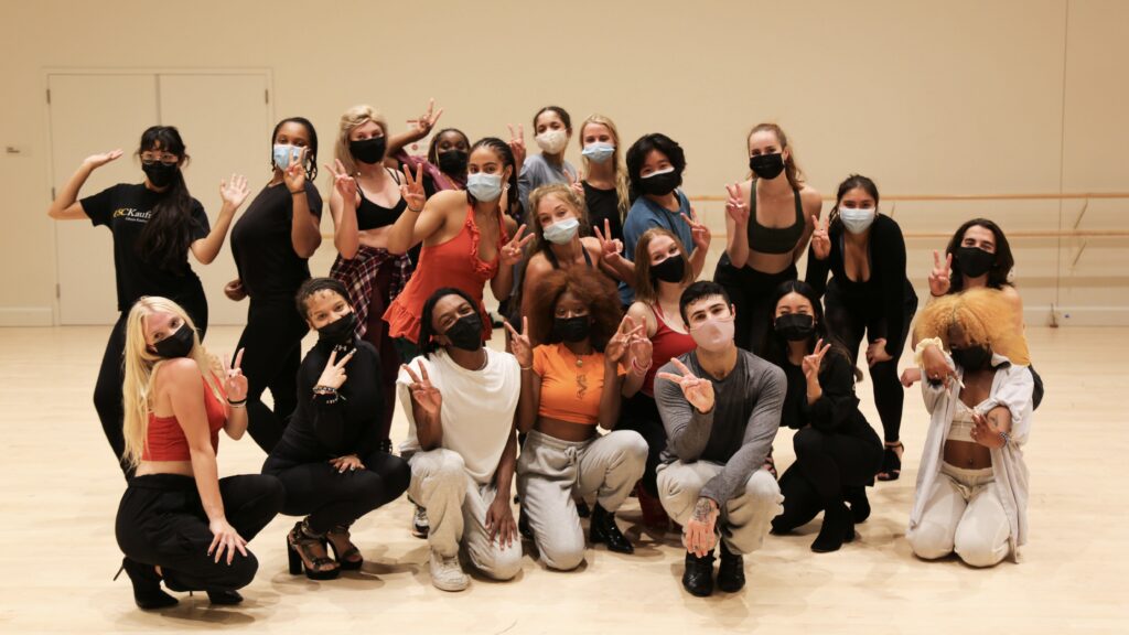 a group of dancers in heels pose for a photo