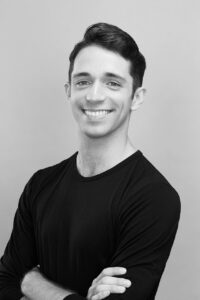 Black and white photo of Michael Breeden smiling with his arms crossed