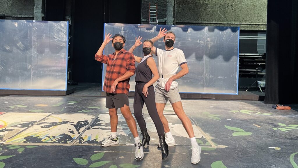 three dancers pose on an empty stage