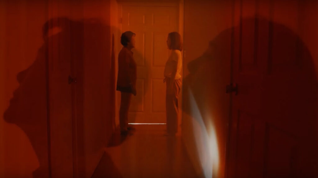 Korean grandmother and granddaughter stand facing each other in front of door