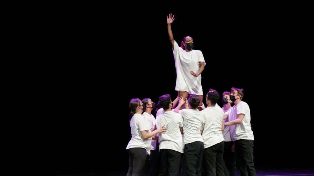 dancers performing Tessandra Chavez' choreography. A group of dancers hold up one dancer whose arm is outstretched upwards