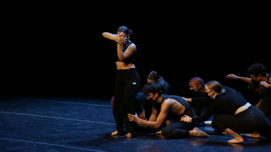 one dancer standing while other dancers group around her feet. Captured during the performance of Toyin Sogunro's The Artist's Struggle for Integrity