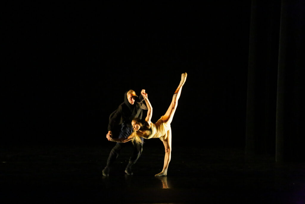 two dancers partnering on stage during a show