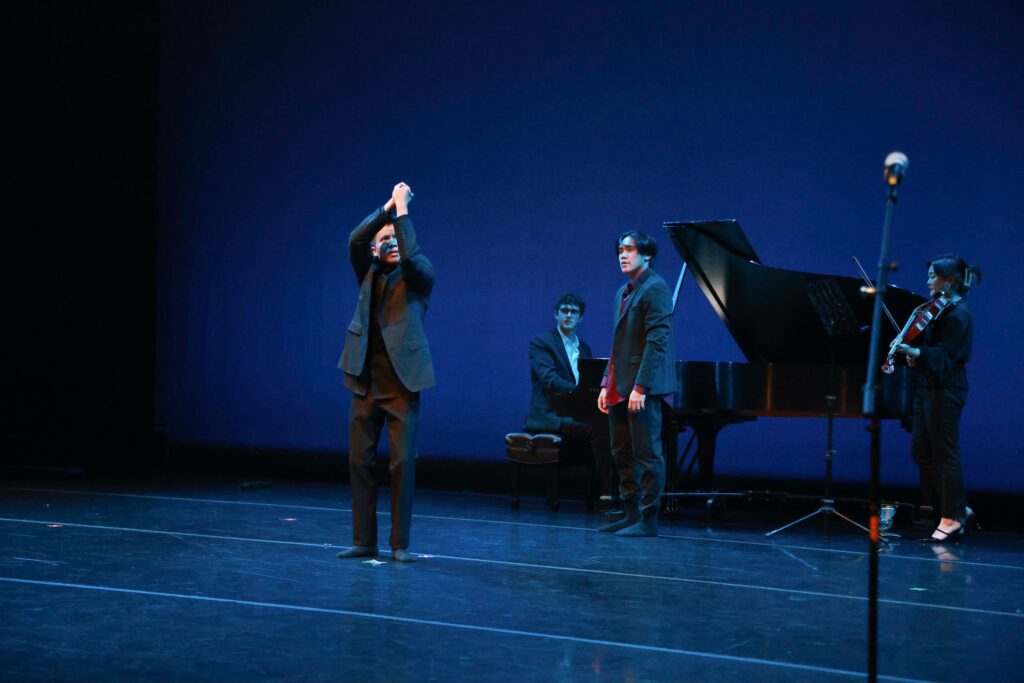 two dancers perform on stage with a pianist and a violin player