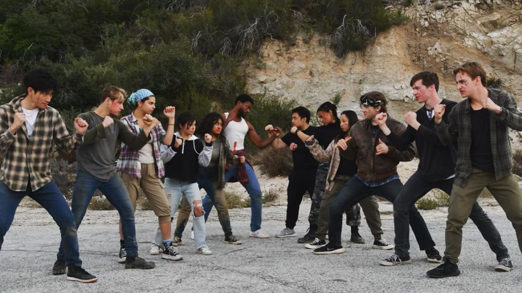 a group of people stand in a face off, in fighting stances, in the mountains