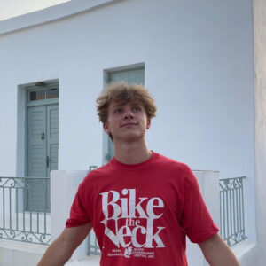 Atticus Dobbie (BFA '24) pictured in a red "Bike the Neck" shirt, enjoying his summer 