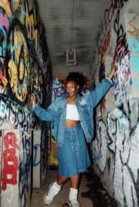 Simone Peterson (BFA '26) posing for the camera in a graffiti corner 